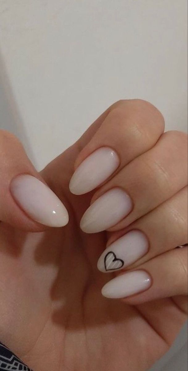 Chic Almond-Shaped Nails with Light Nude Hue and Playful Black Heart Design