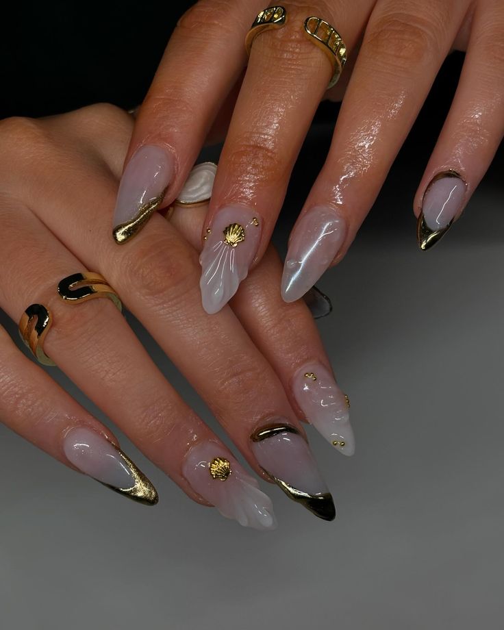 Chic Almond-Shaped Nails with Intricate Designs and Gold Accents for Glamorous Elegance.