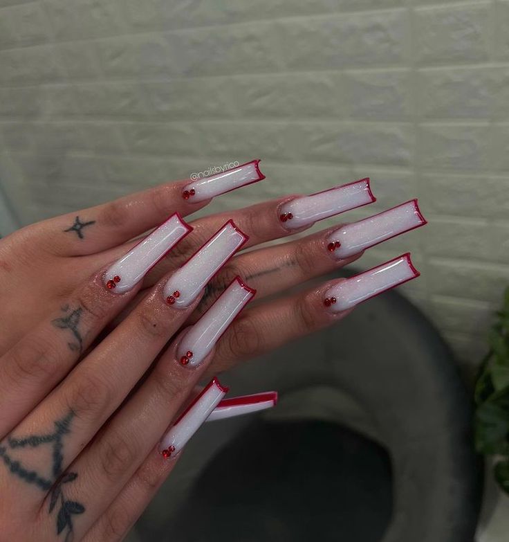 Chic Red-Tipped Nail Art with Clear Base and Delicate Embellishments