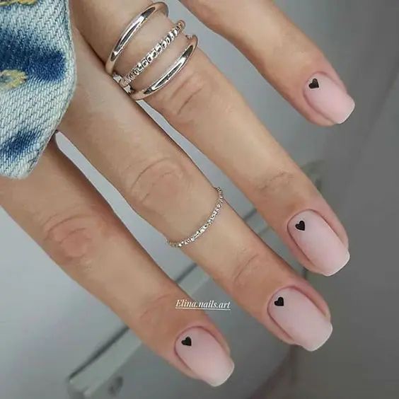 Chic Minimalist Nail Design with Soft Pink Base and Black Heart Accents