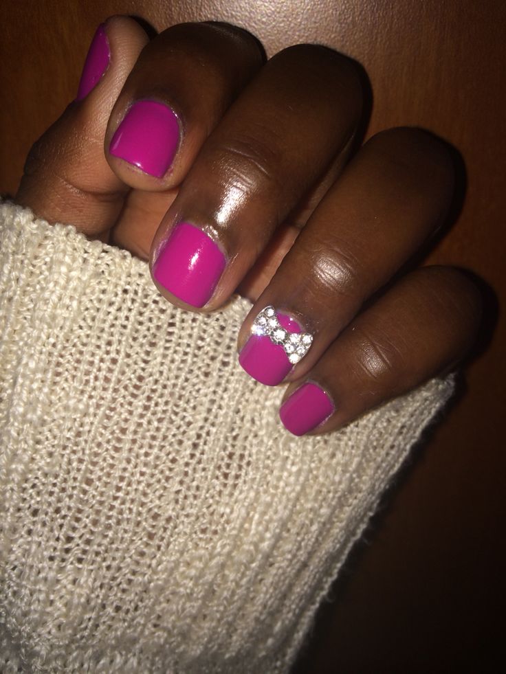 Playful and Sophisticated Vibrant Pink Nail Design with Rhinestones and Swirls.