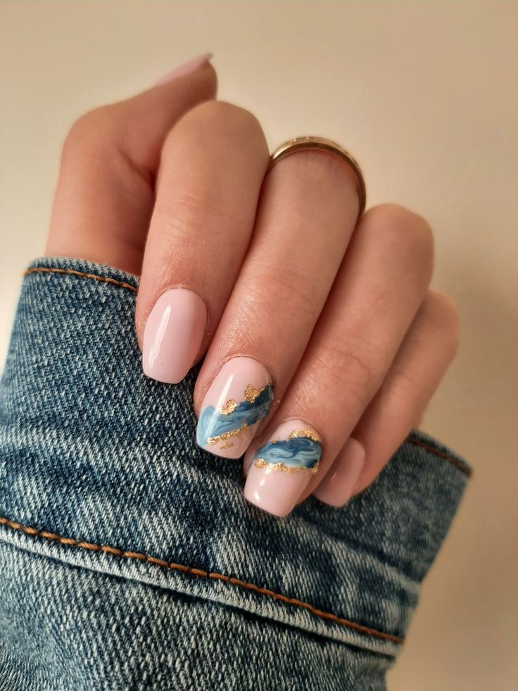 Elegant Soft Pink Nail Design with Artistic Blue Swirls and Gold Accents