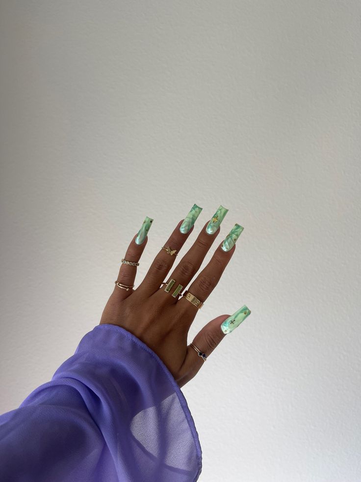 Chic Green Marble Acrylic Nails Enhanced with Gold Rings.