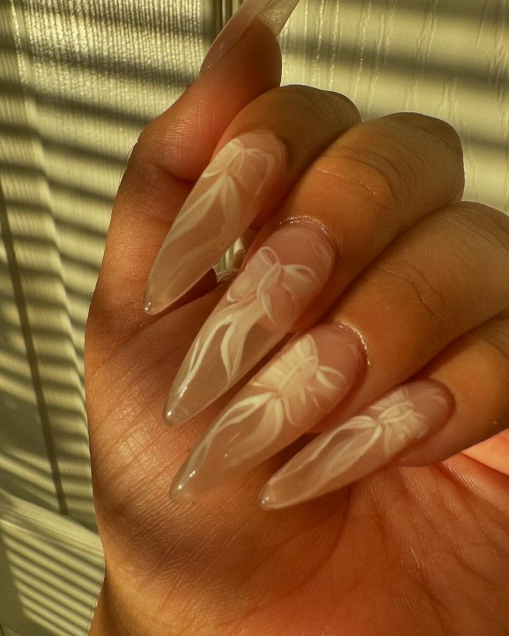 Sophisticated Nail Design: Elongated Nude Acrylics with Intricate White Floral Patterns.