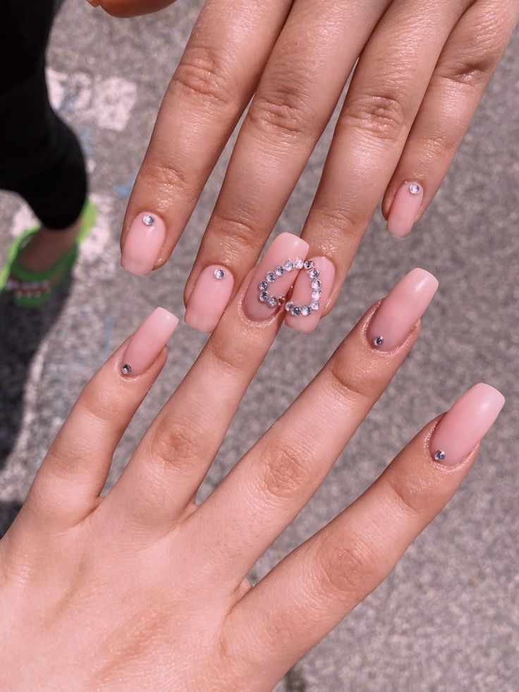 Elegant Soft Pink Nail Design with Heart-Shaped Rhinestone Accent.