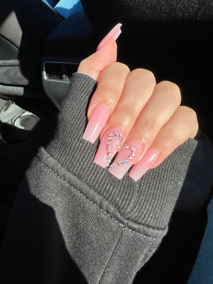 Elegant Soft Pink Gradient Acrylic Nail Design with Playful Heart and Colorful Rhinestones.