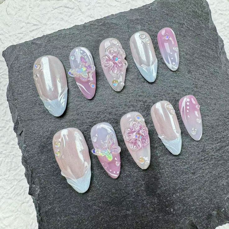 Sophisticated Nail Design: Soft Pink and Clear Tones with Glamorous Floral Embellishments.