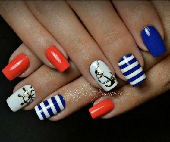 Nautical-Inspired Nail Design: Vibrant Coral, Deep Blue, and Crisp White Aesthetics with Bold Stripes and Anchor Motif.