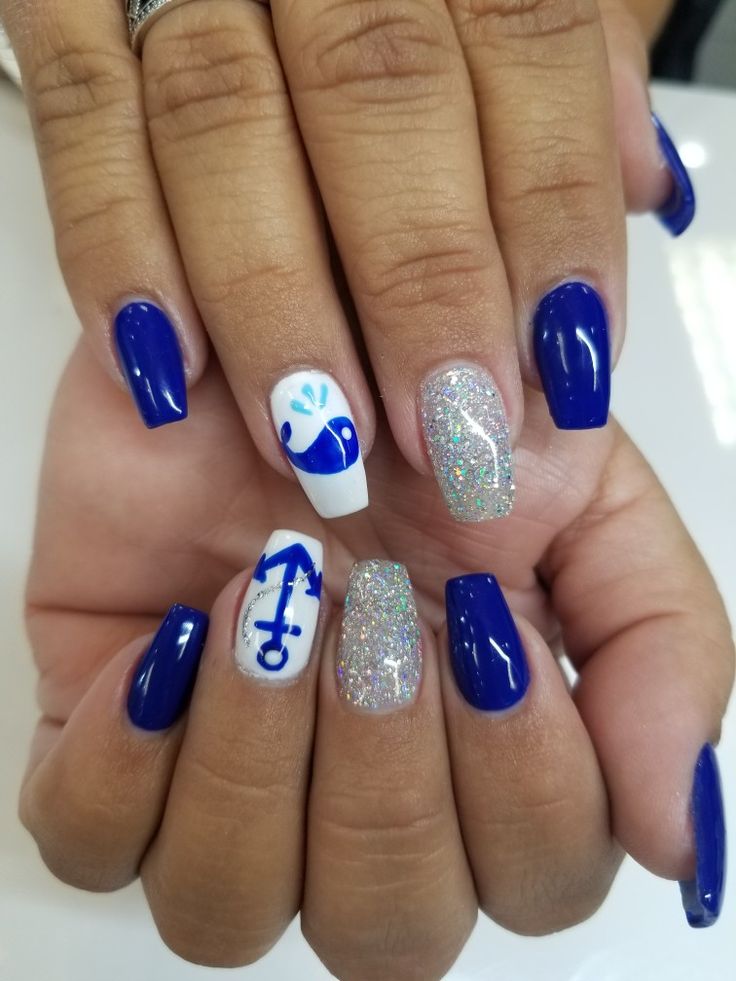 Vibrant Blue Nail Design: A Striking Contrast with Glitter and Nautical Whimsy.