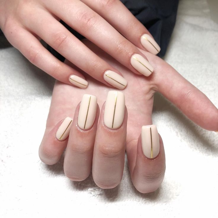 Sophisticated Elegant Nude Nail Design with Minimalist Gold Stripes.