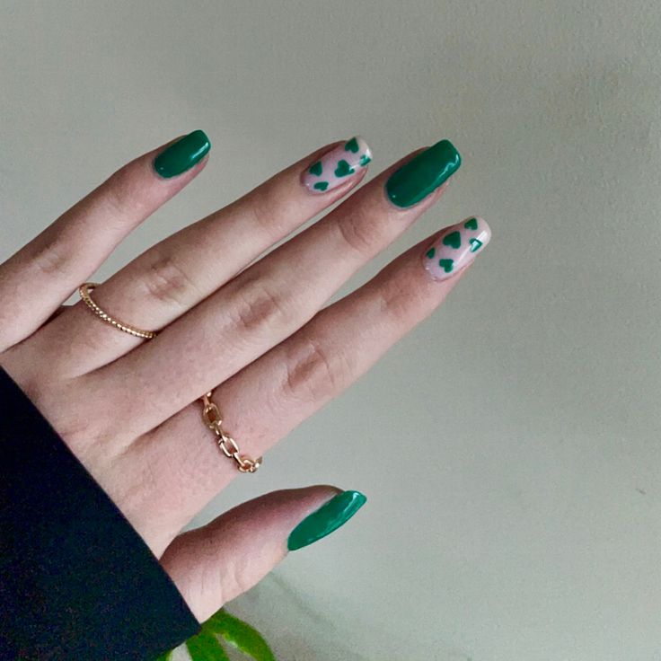 Chic Green Nail Design: Glossy Emerald with Playful Heart Patterns for Every Occasion.