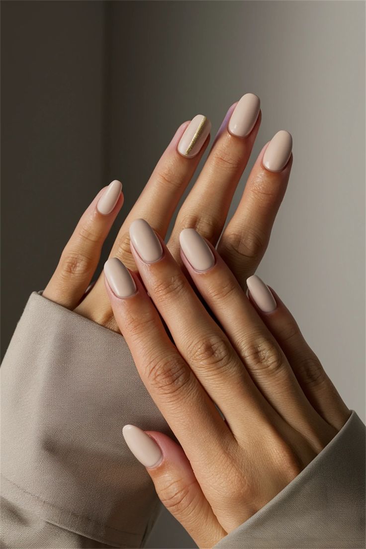 Chic Nail Design: Soft Nude Polish with a Metallic Accent Stripe