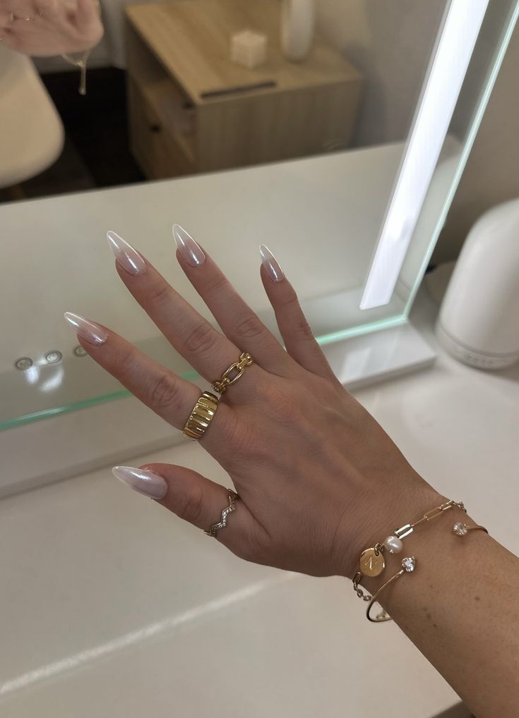 Chic Almond-Shaped Nails with Glossy White Finish and Stylish Gold & Silver Rings