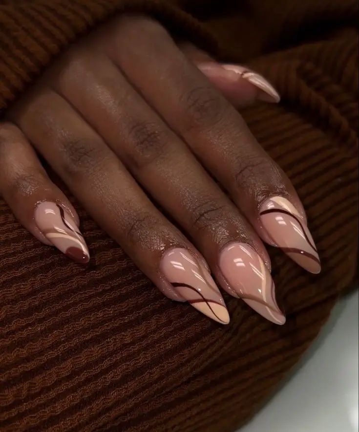 Chic Stiletto Nail Design: A Sophisticated Blend of Nude and Soft Pink Tones with Artistic Elegance.