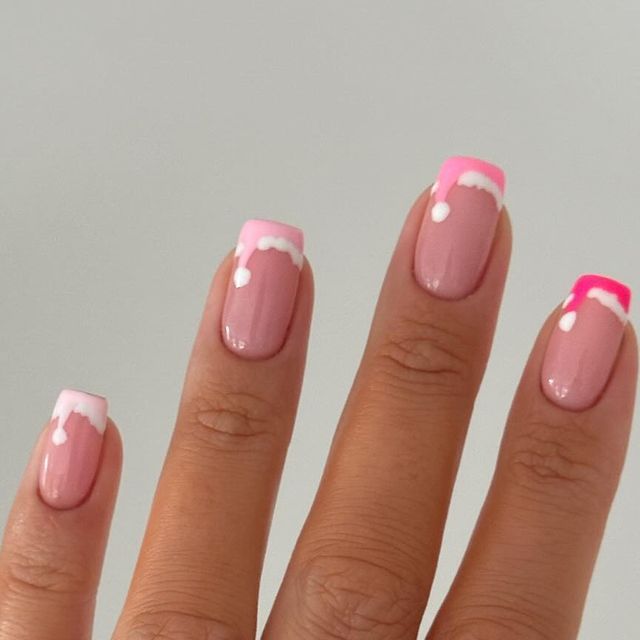 Springtime Pastel Nail Art: Soft Pink Base with Gradient Tips and White Accents.