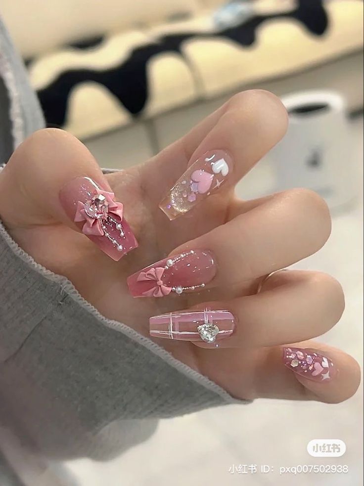 Elegant Soft Pink Nail Design with Floral Motifs and Delicate Embellishments