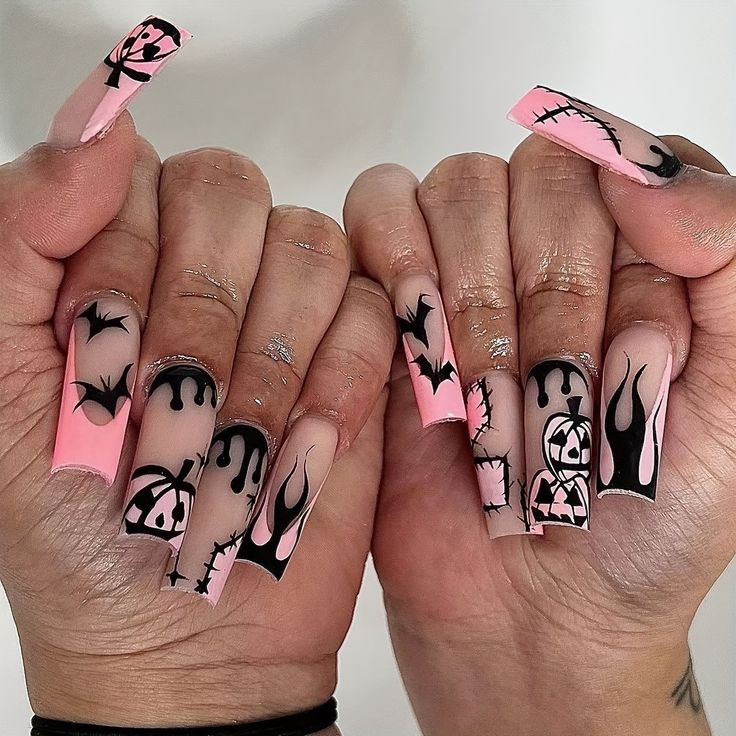 Edgy Whimsical Nail Art: Bold Pink and Black Design with Bats, Flames, and Playful Motifs.