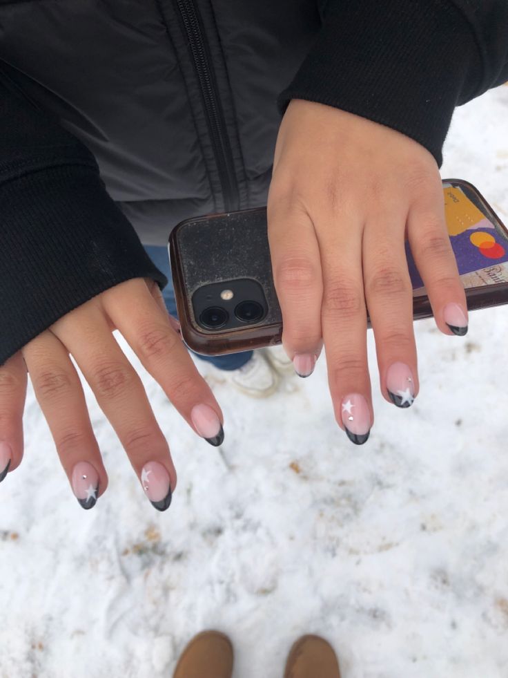 Chic French Tip Nail Design with Soft Pink, Black Tips, and Delicate White Stars