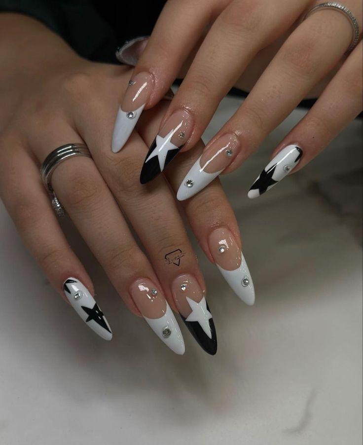 Chic Black and White Nail Design with Geometric Shapes and Glamorous Rhinestone Accents.