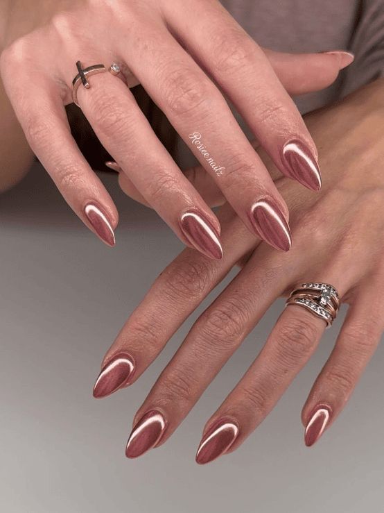 Sophisticated Rose Gold Almond Nails with Modern White Accents and Delicate Rings.