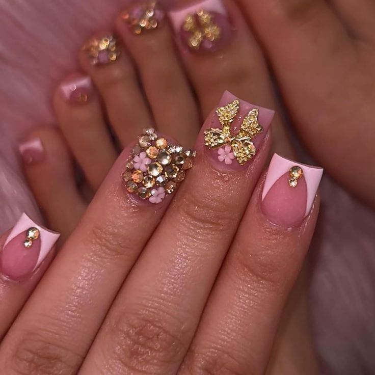 Elegant Glistening Nail Design: Soft Pink and French Tips with Golden Butterflies and Rhinestones.