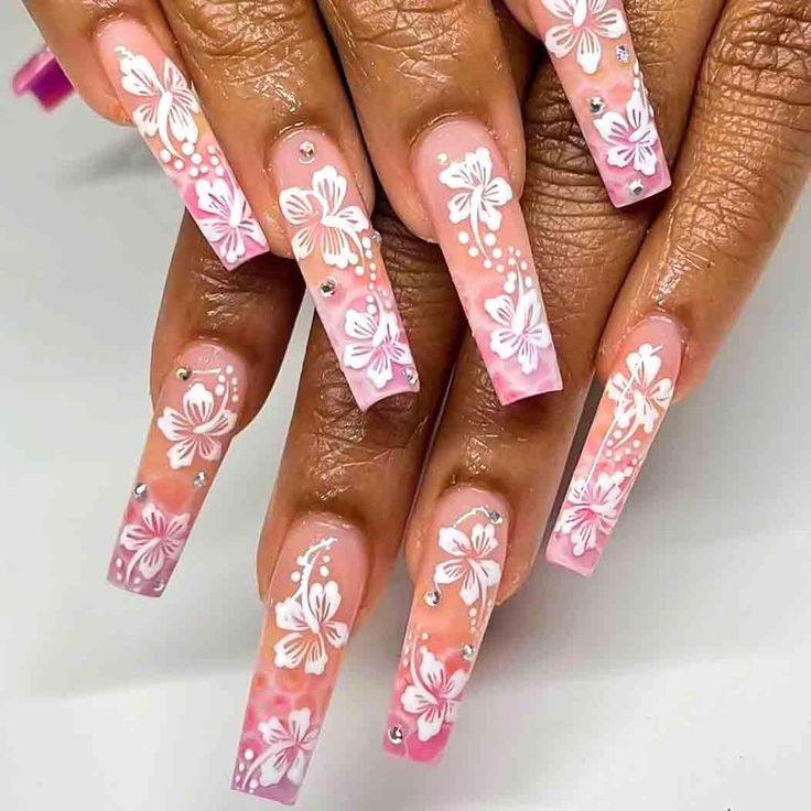 Charming Floral Ombre Nail Design with Intricate White Patterns and Rhinestones.