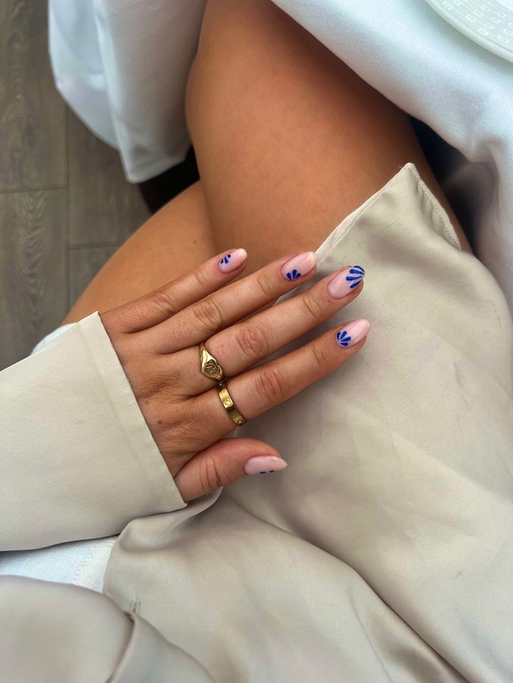 Chic Elegant Nude Nail Design with Delicate Blue Floral Patterns.