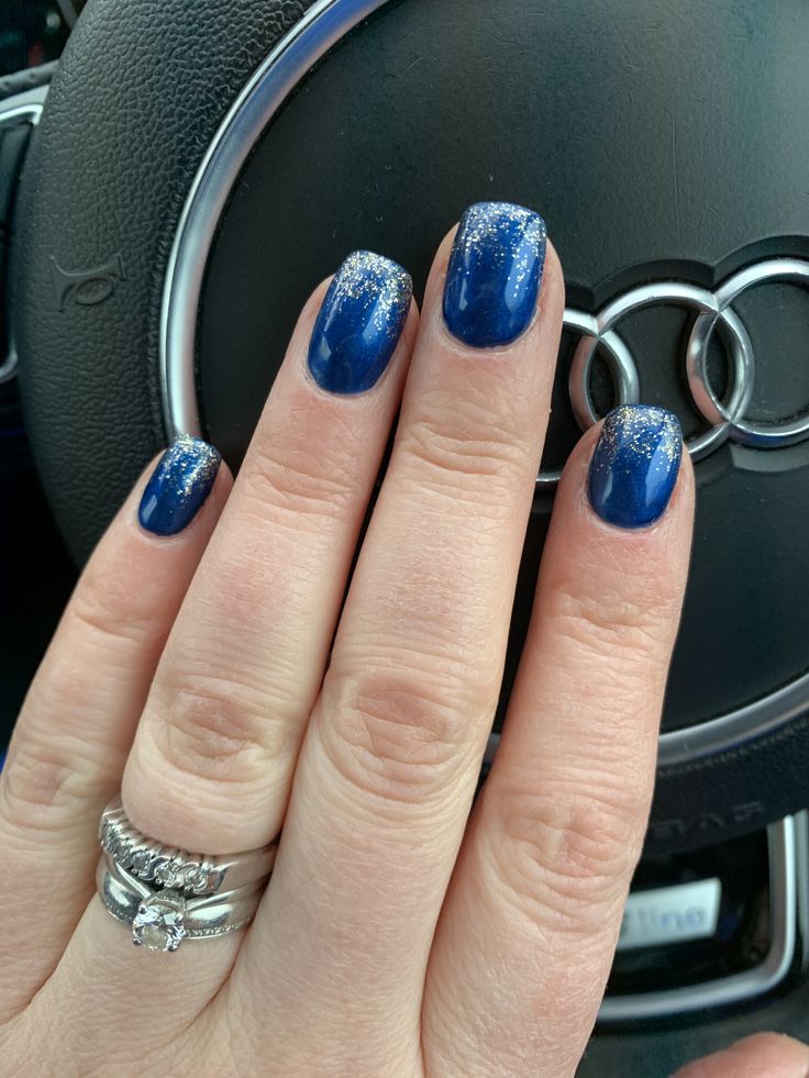 Sophisticated Elegant Blue Nail Design with Glossy Navy Base and Shimmering Silver Glitter Tips.