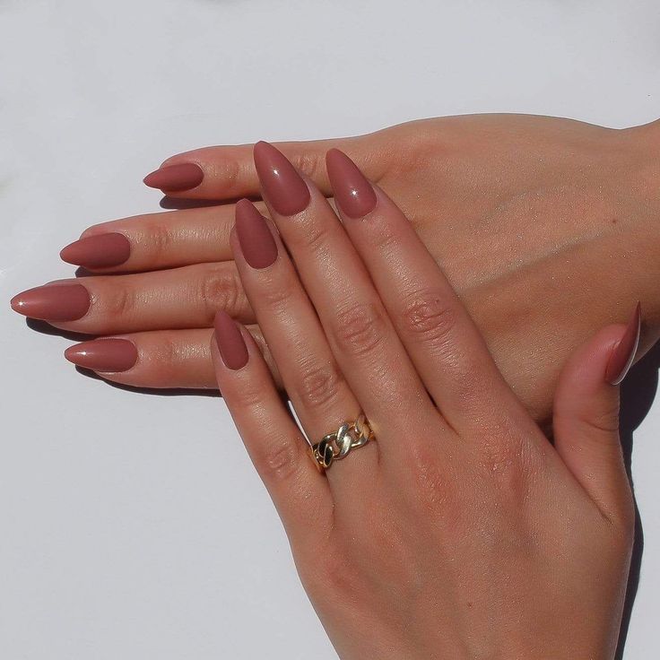 Elegant Almond-Shaped Nails in Warm Mauve with Sophisticated Matte Finish and Gold Ring Accent.