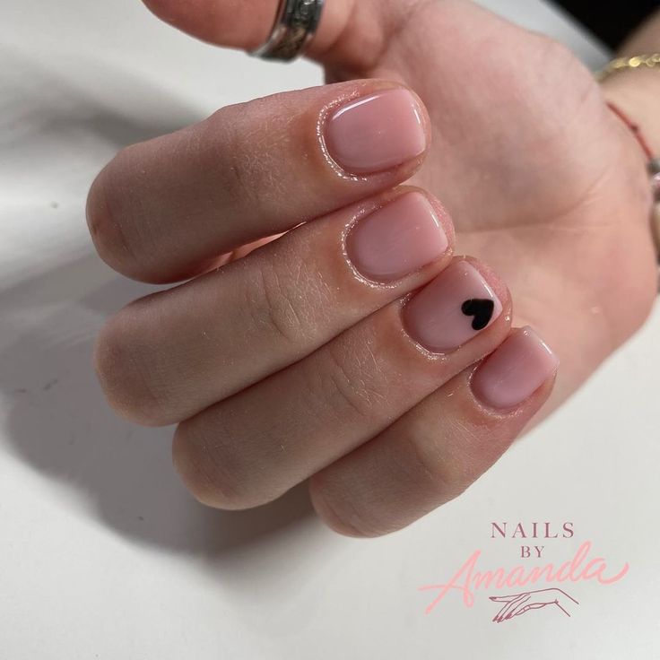 Chic Minimalist Nail Design: Soft Pink Base with Playful Black Heart Detail