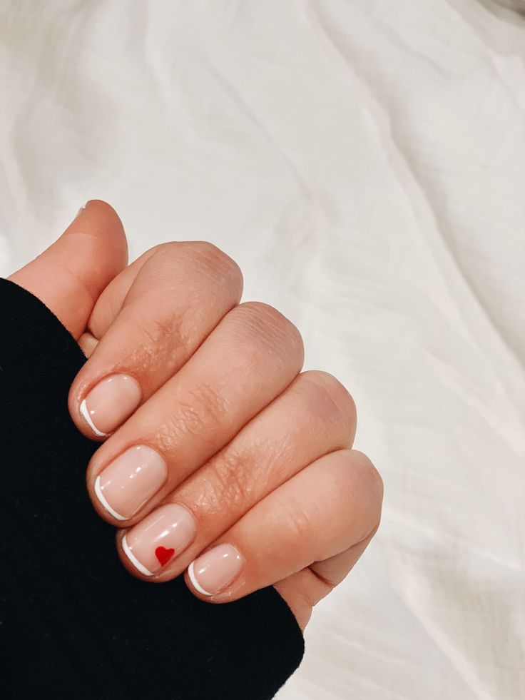 Charming Nude and White Nail Design with Playful Red Heart Accent.