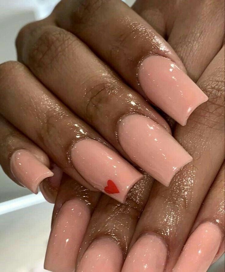 Charming Nude Nail Design with Delicate Red Heart Accent.