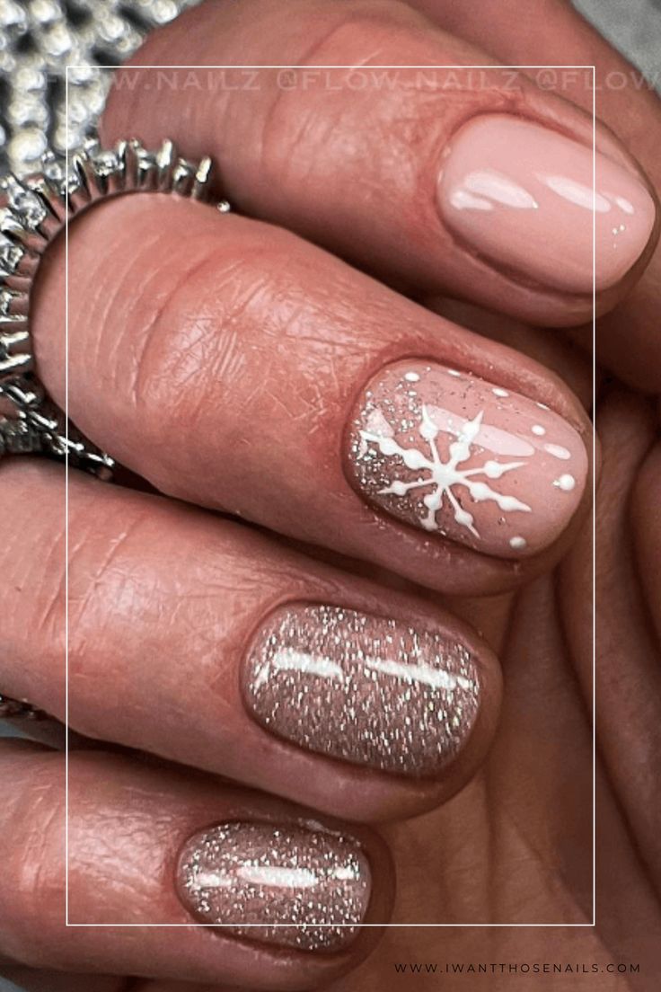 Charming Winter Manicure: Soft Pink Base with Snowflake Accent and Sparkling Glitter.