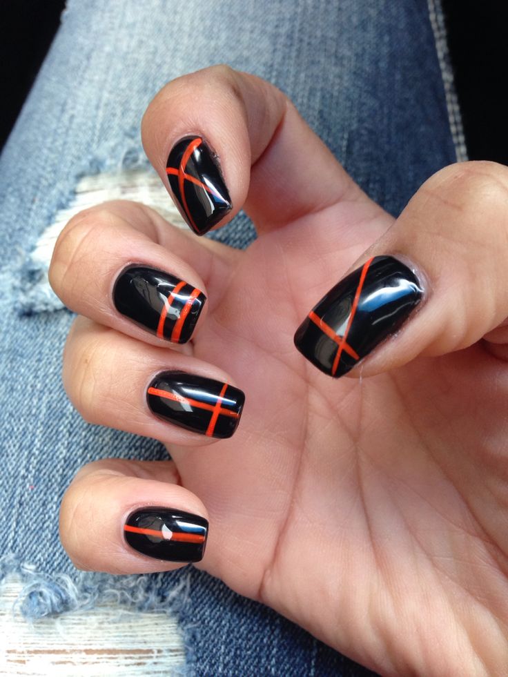 Bold Black Nails with Vibrant Orange Accents: A Stylish and Edgy Design.