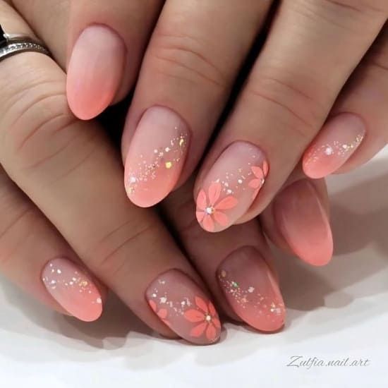 Elegant Gradient Nail Design with Soft Peach Hues and Floral Accents.