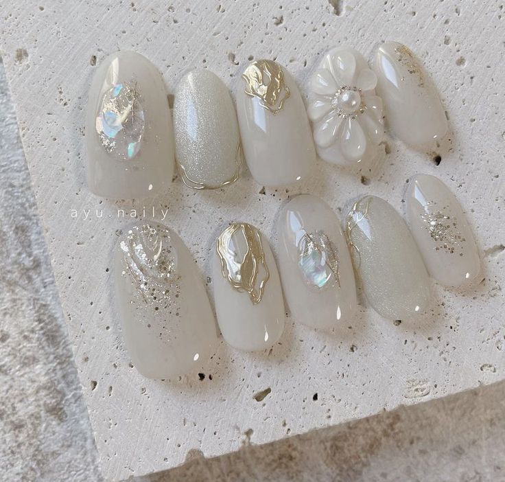 Sophisticated Nail Design with Soft Whites and Shimmering Floral Accents