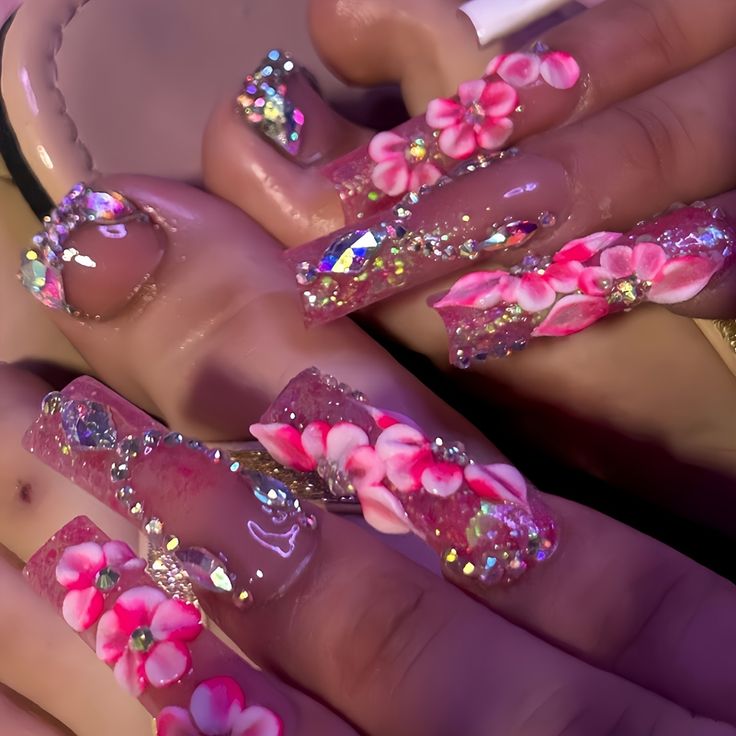 Playful Elegance: Vibrant Acrylic Nail Design with Pink Flowers and Sparkling Gems.