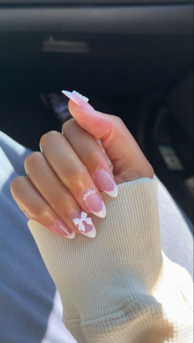 Chic Soft Pink Nail Design with White French Tips and Floral Pearl Accents.