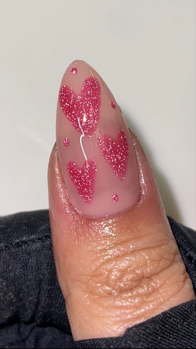 Charming Heart-Themed Nail Design with Glossy Pink Polish and Glittery Red Accents.