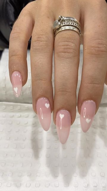 Elegant Soft Pink Gradient Nail Design with Heart Accents for Romantic Occasions.