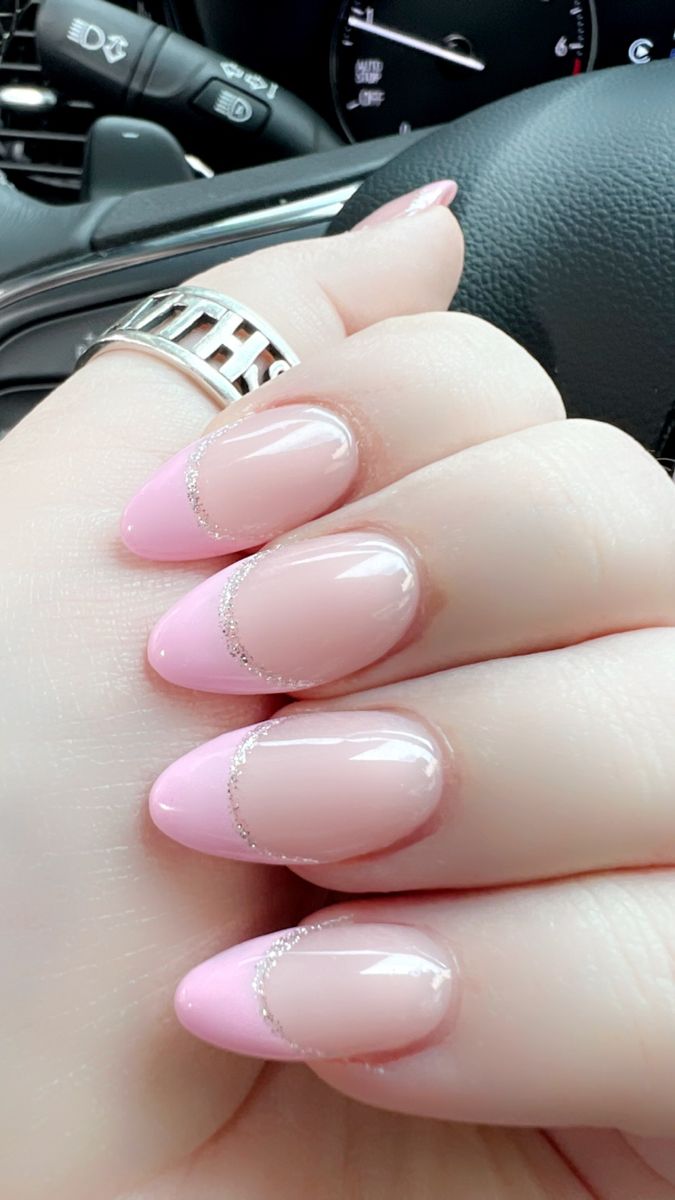 Chic Elegant Pink French Tip Manicure with Subtle Glitter and Almond Shape.