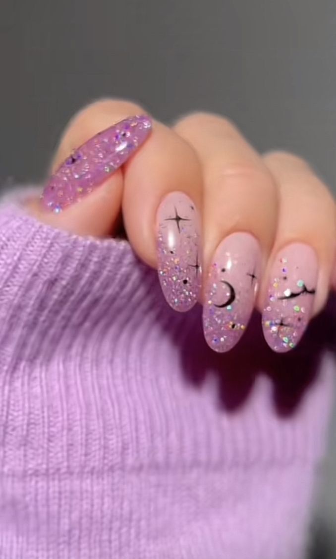 Whimsical Elegant Nail Art: Soft Pink Base with Glitter and Black Accents.