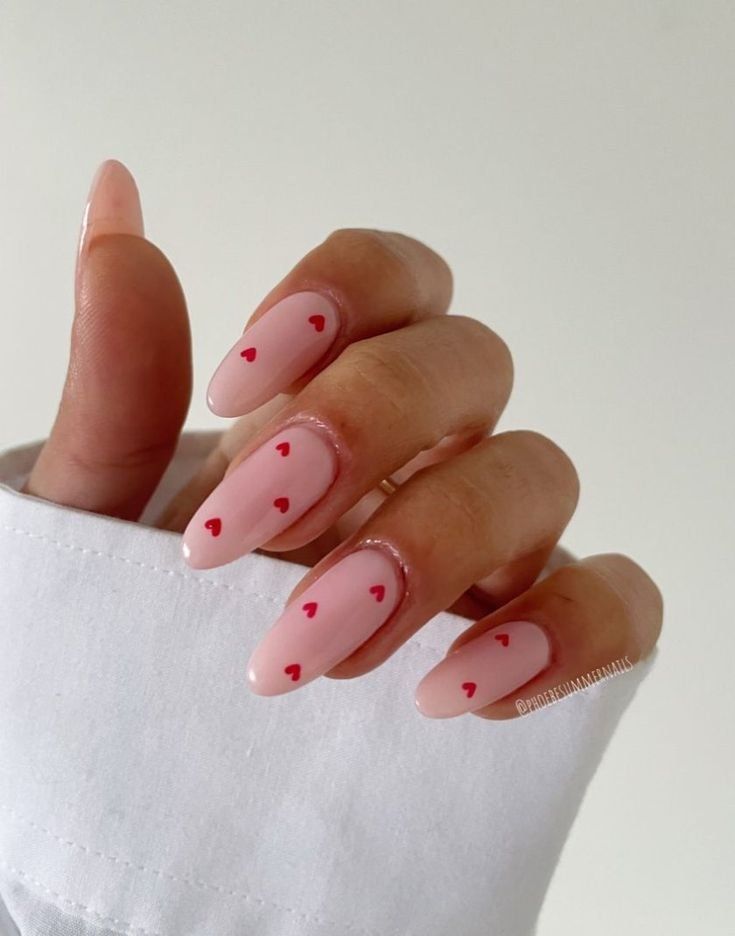 Elegant Heart-Themed Nail Design in Soft Pink with Delicate Red Accents.