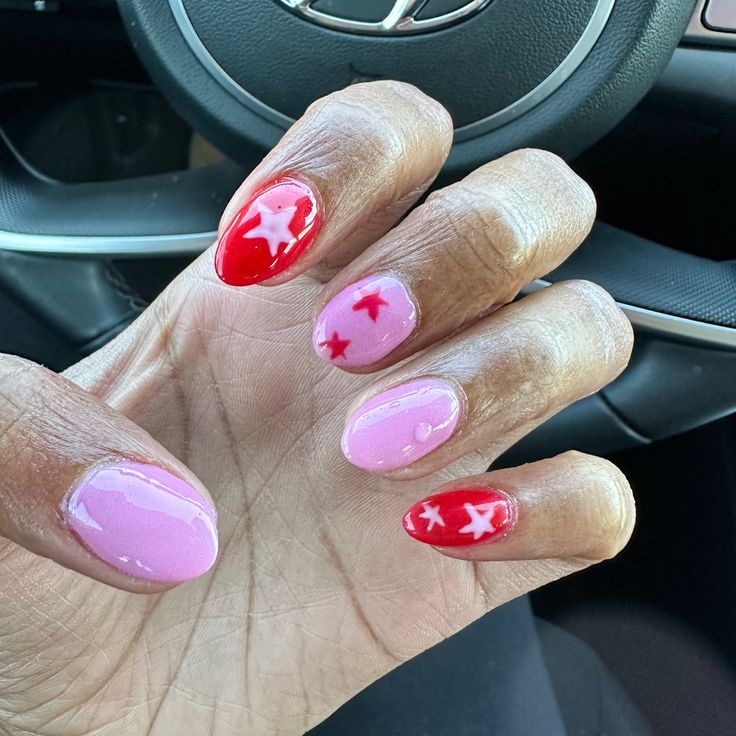 Playful Pink and Red Nail Design with Glossy Finishes and Star Motifs.