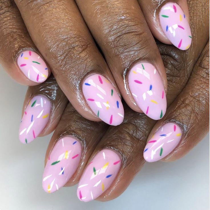 Cheerful Colorful Sprinkle Nail Design: Soft Pink Base with Vibrant Speckles.