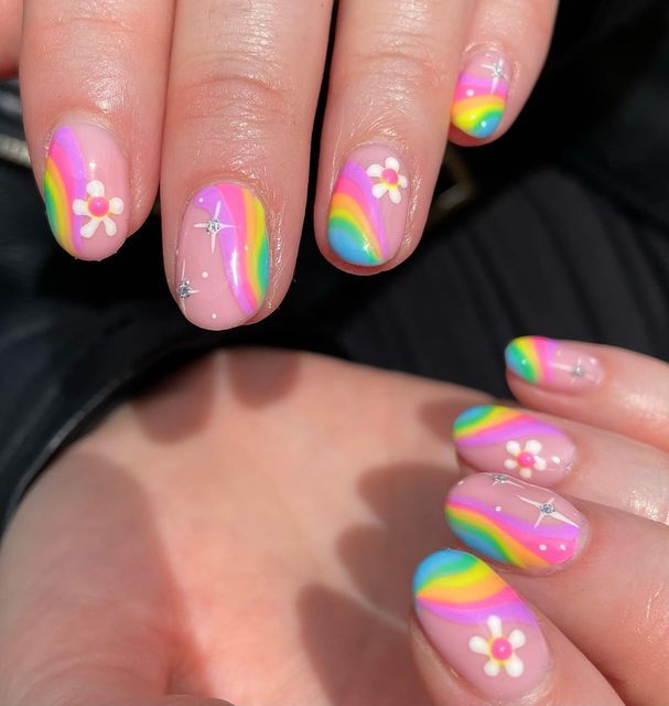 Whimsical Pastel Nail Design with Rainbow Waves and Sparkling Rhinestones.