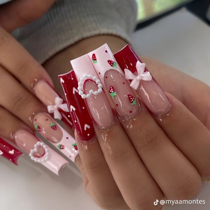 Whimsical Pink and Red Nail Design with Strawberry Patterns and Glossy Finish for Festive Elegance.