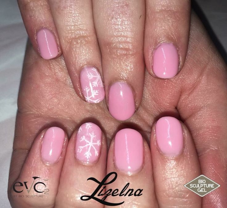 Delicate Pink Nail Design with Elegant Snowflake Accents for Winter Celebrations.