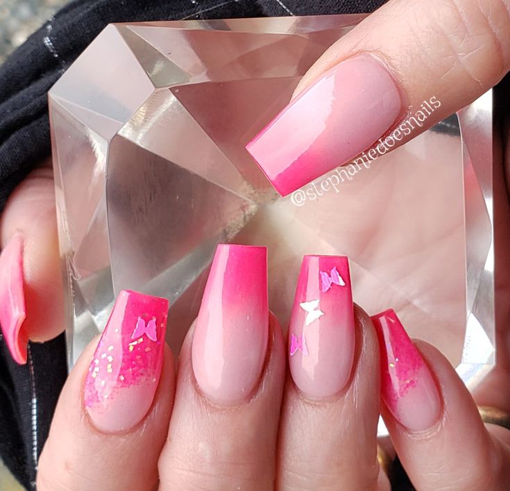 Cheerful Ombre Pink Nail Design with Glitter Accents and Bow Embellishments.