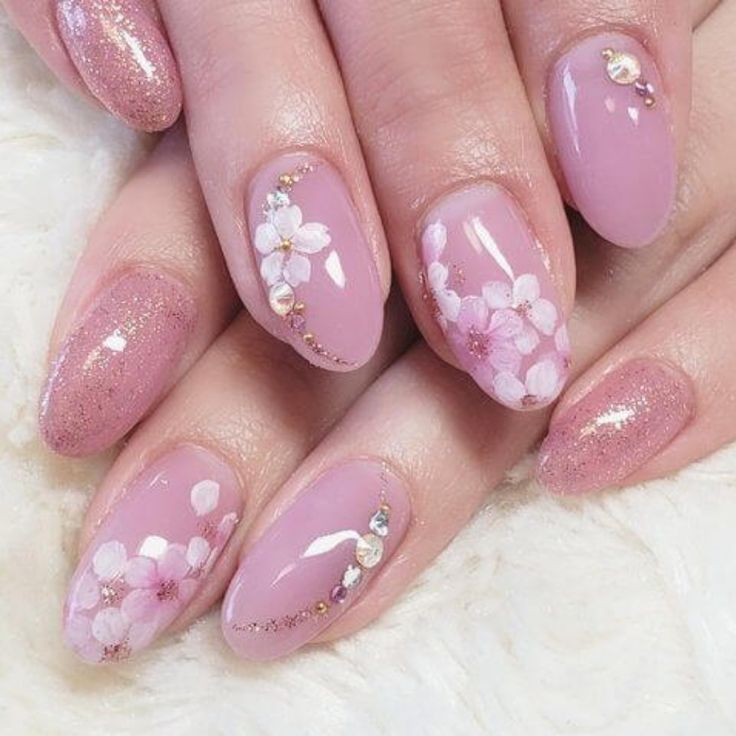 Chic Pastel Pink Floral Nail Design with Glitter and Elegant Accents.